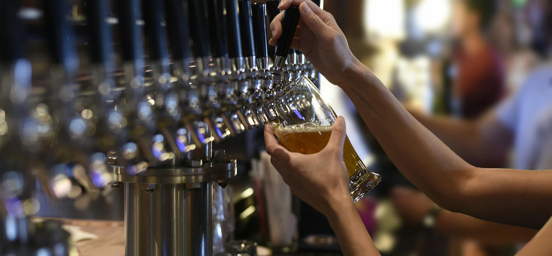 barman tirant une bière derrière un bar