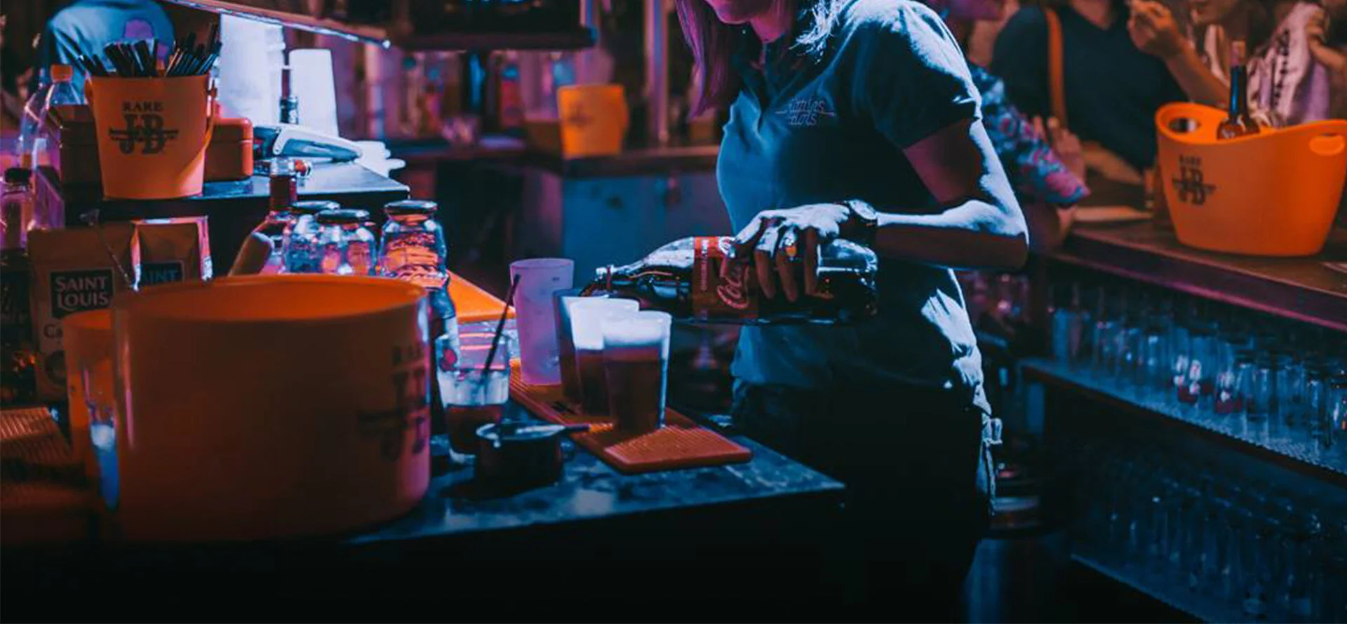 Serveuse préparant des boissons derrière un bar lors d'un événement