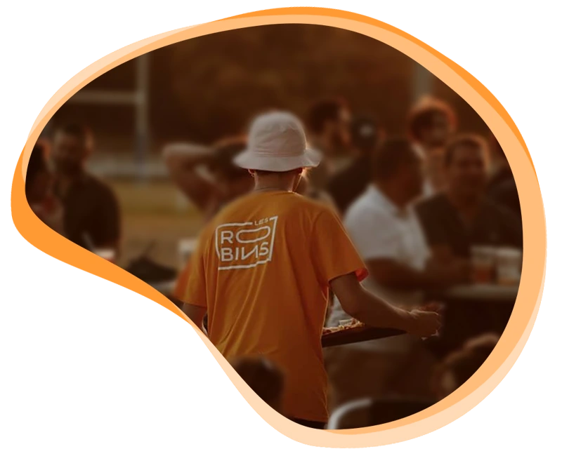 Serveur avec le tee-shirt des Robins qui amène des plats lors d'un événement